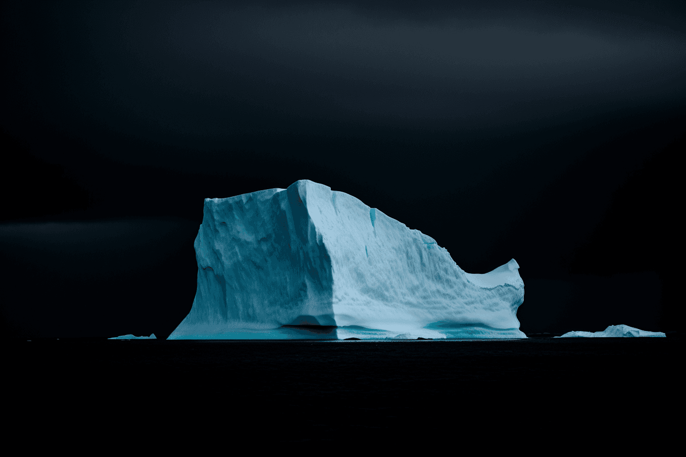 A photograph of an iceberg in the Arctic, with the blue and white colors contrasting against a dark sky.