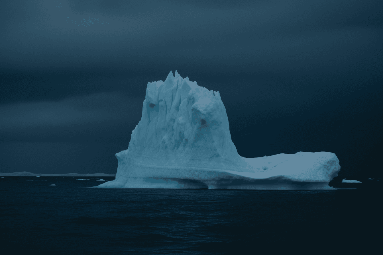 A photograph of an iceberg in the Arctic, with the blue and white colors contrasting against a dark sky.